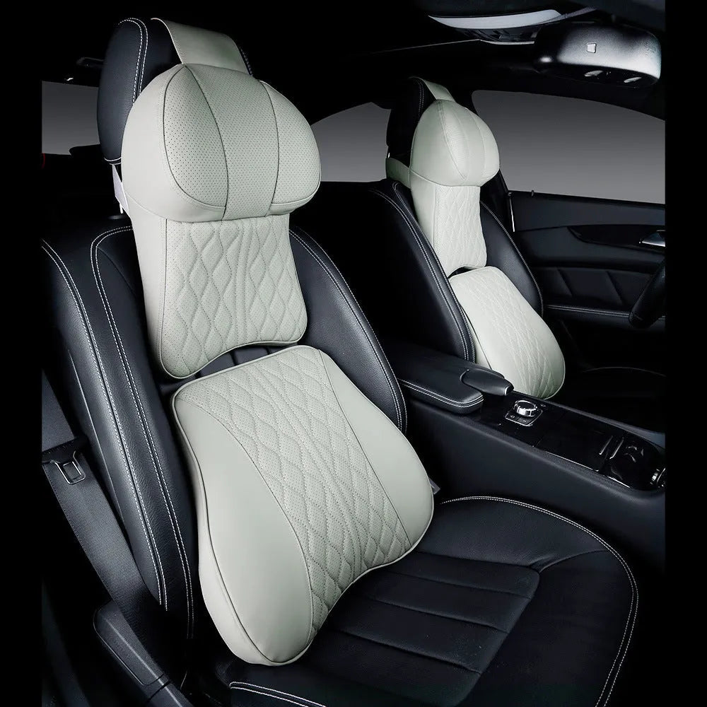 Beige and black car neck pillow and lumbar support pillow set on a car seat.
