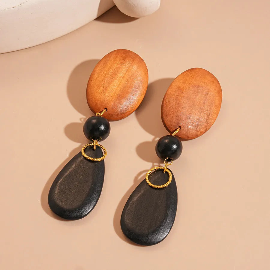 Hand-crafted wooden oval earrings in silver needle and brown-black retro style.