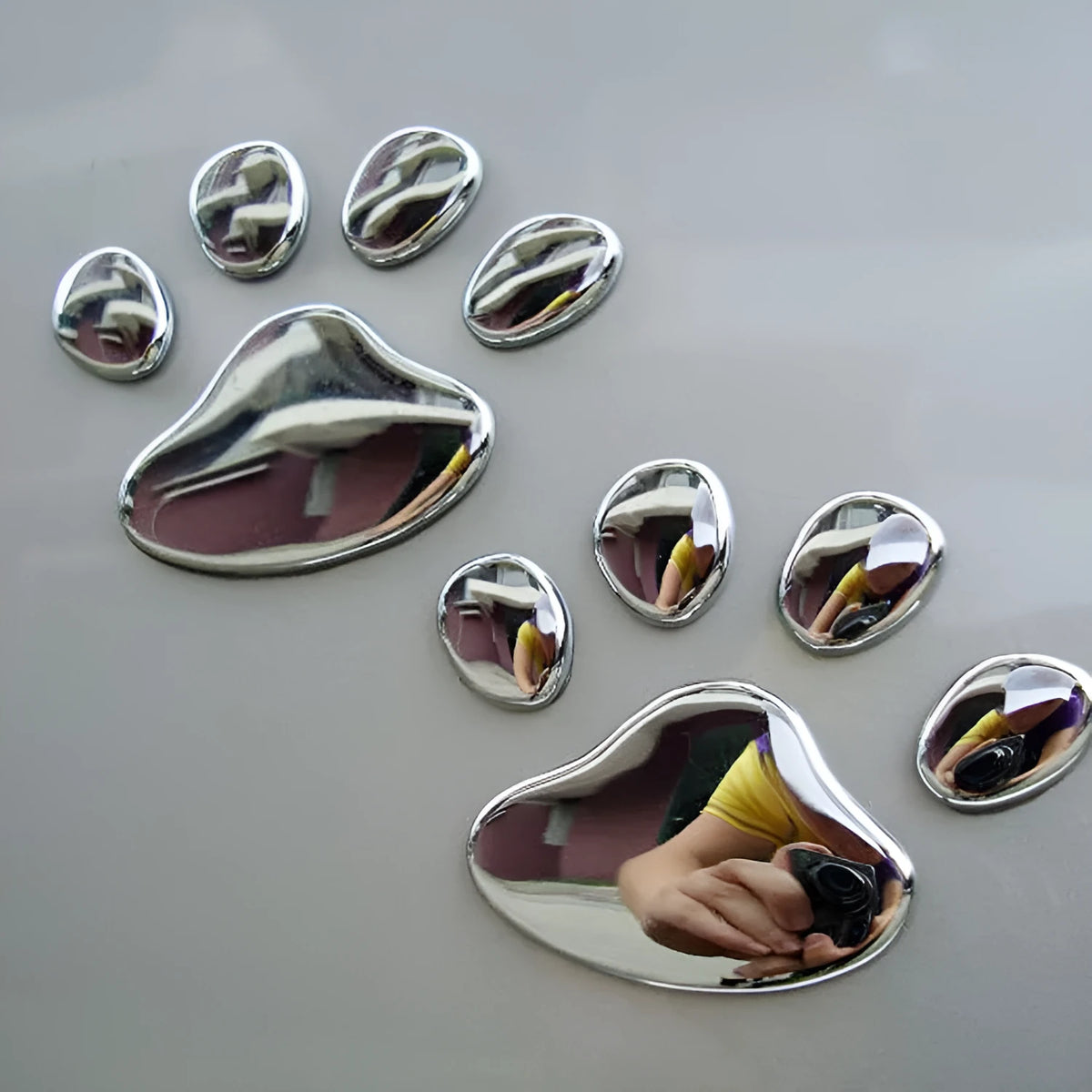 PVC car sticker with 3D hand-shaped brush texture forming dog footprints, in black, gold, red, or silver.