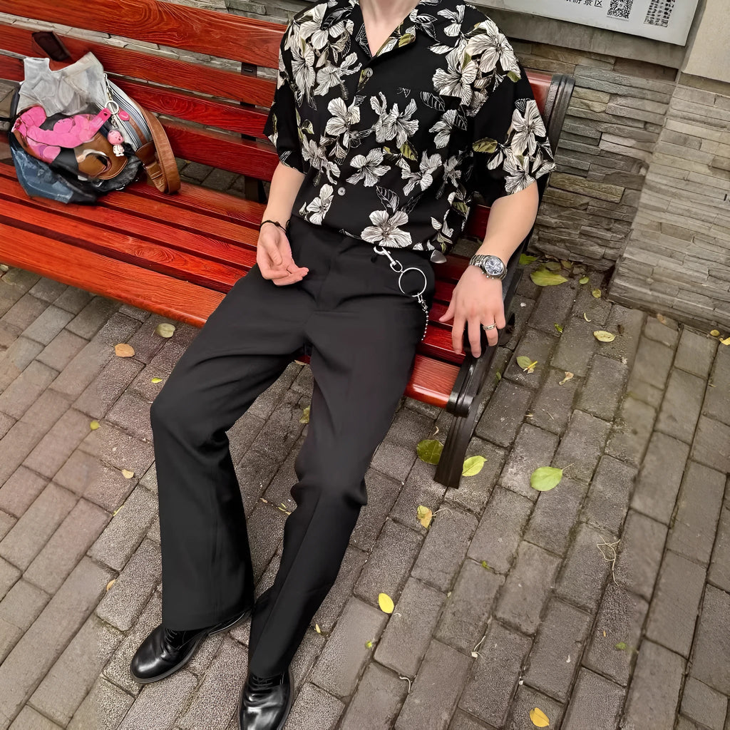 Black men's ice silk shirt with floral print, Cuban collar, and short sleeves on a hanger.