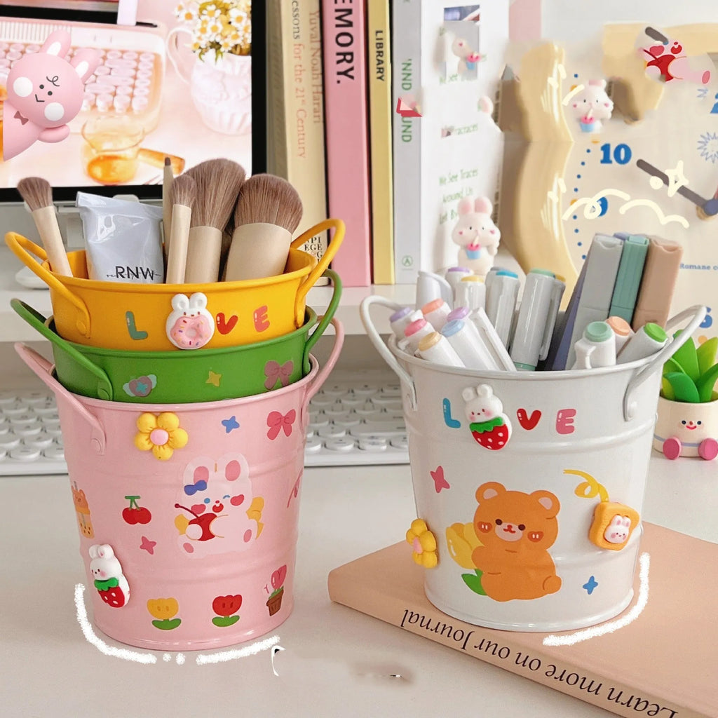 Round metal pen holder with iron art design in various colour options on a desk