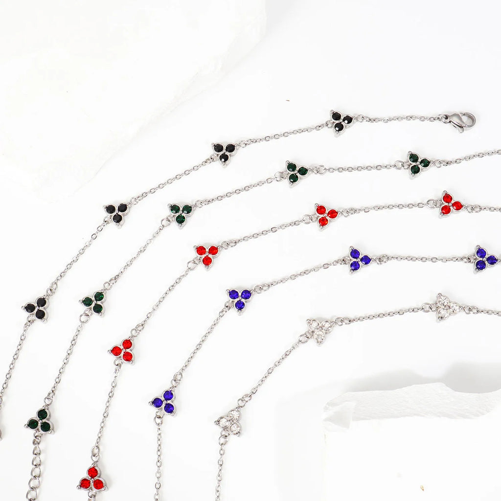 Women's stainless steel geometric bracelet with three diamonds and a coloured zircon stone in a triangular setting.
