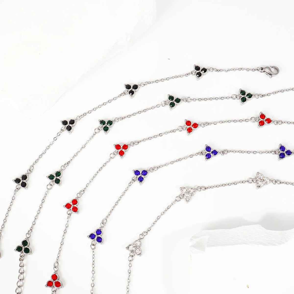 Women's stainless steel geometric bracelet with three diamonds and a coloured zircon stone in a triangular setting.