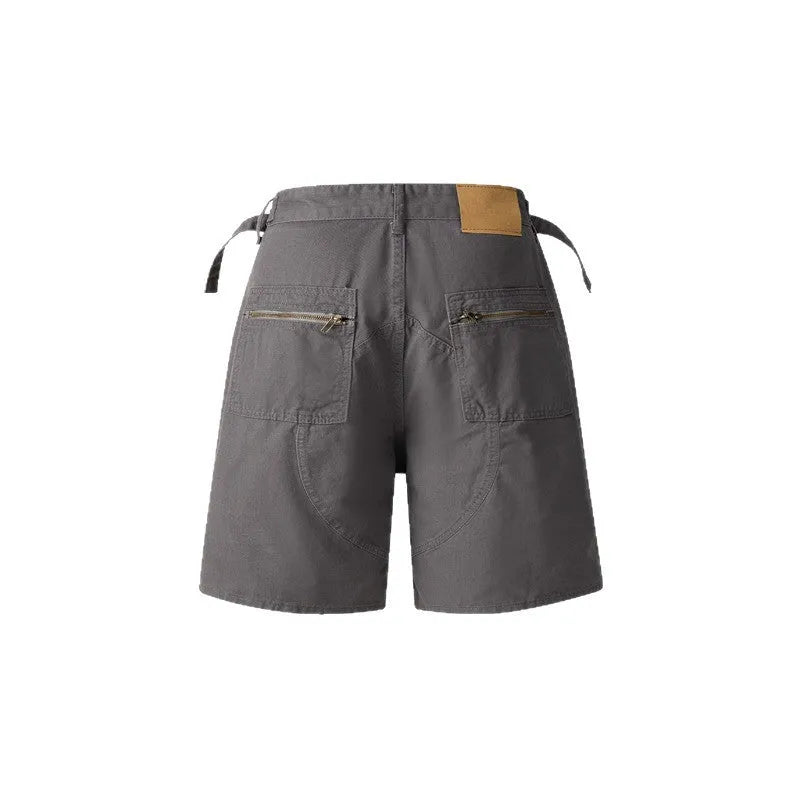 Men's and women's grey washed cotton retro workwear shorts with a loose fit and half elastic waistband on a hanger.