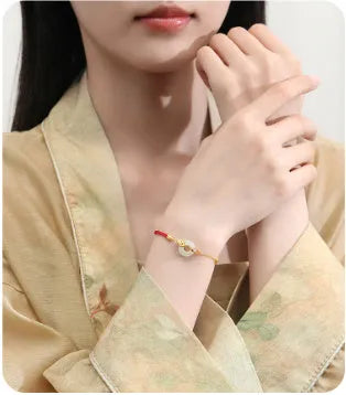 Women's silver bracelet with gold koi design and red rope adjustment