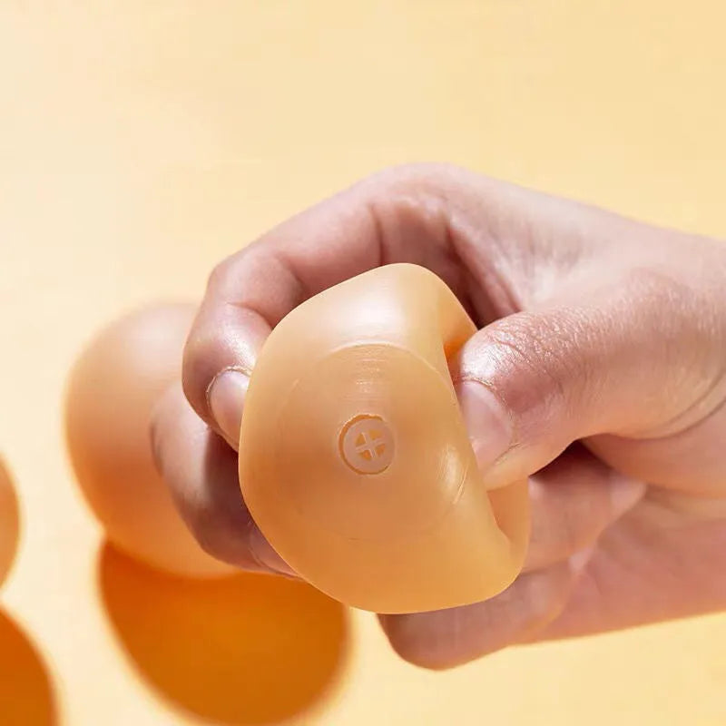 Yellow egg-shaped dog teeth cleaning toy with textured rubber surface for dental care