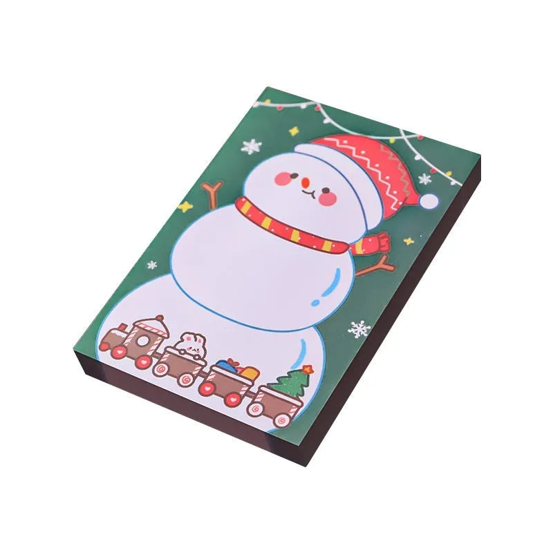 Pad of cartoon Christmas sticky notes showing designs of an elf, gift box, sleigh, and Santa Claus.