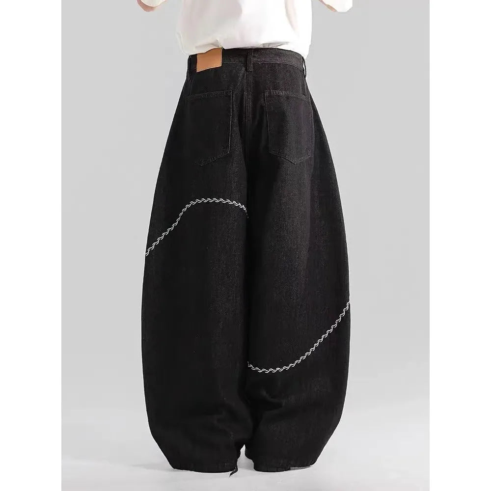 Black straight-leg denim trousers with a mid-waist and zip fly on a plain background.
