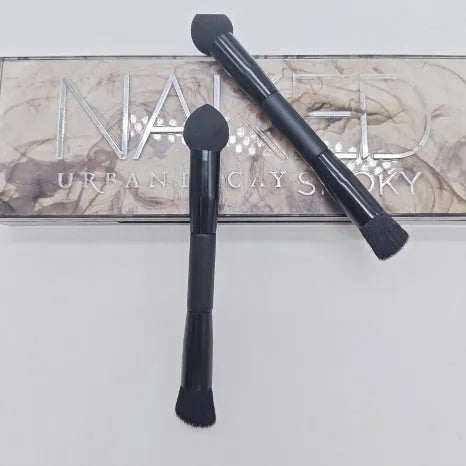 Elegant black double-headed makeup brush with miter sponge and angled concealer heads on a wooden handle.