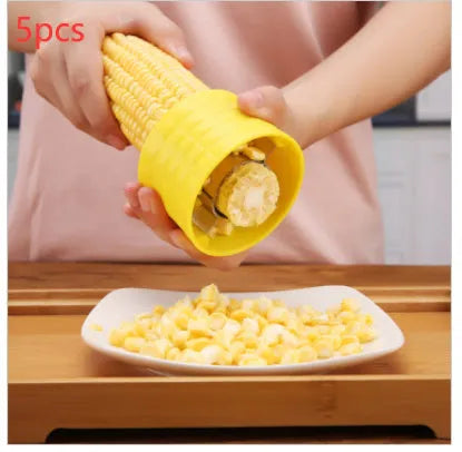 Yellow manual corn thresher kitchen gadget with corn-shaped design and stainless steel gear.