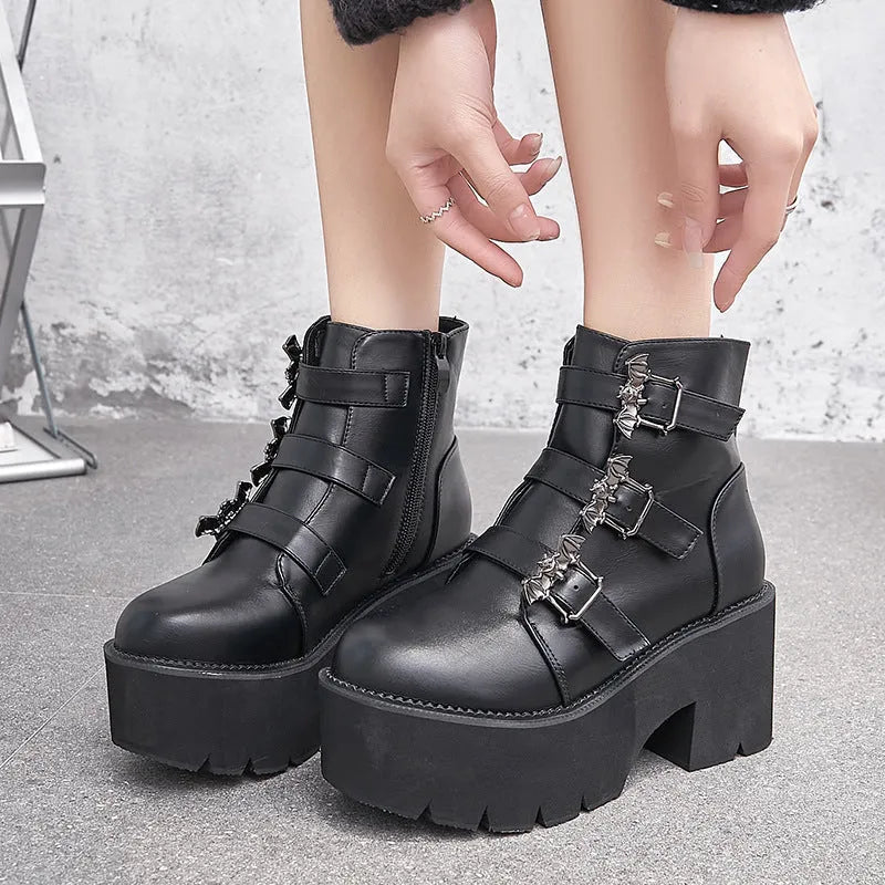 Black women's gothic punk Martin boots with a silver bat buckle and side zip.