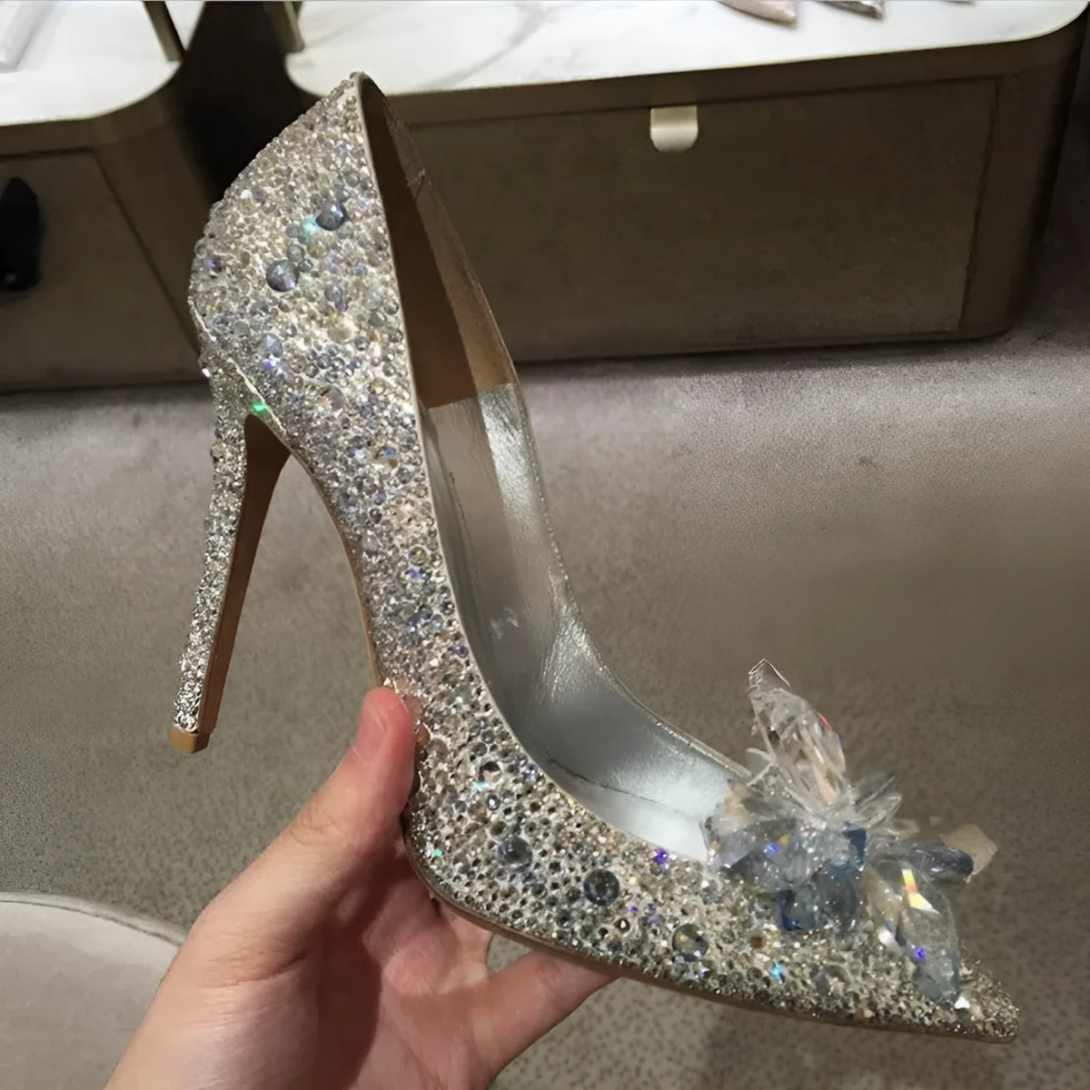 Women's gold stiletto high heels with rhinestone and bow decorations on pointed toe.