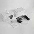 Black ABS USB web camera with magnetic privacy cover on a desk next to a laptop.