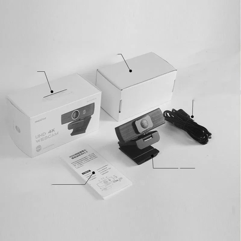 Black ABS USB web camera with magnetic privacy cover on a desk next to a laptop.