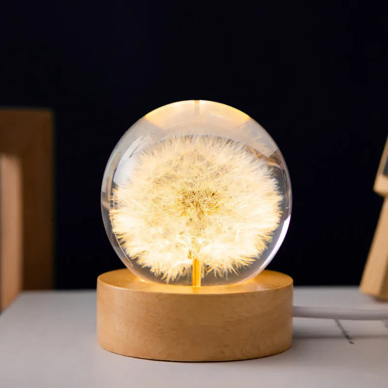 3D dandelion inside a clear resin crystal ball night light on a beech wood stand.