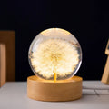 3D dandelion inside a clear resin crystal ball night light on a beech wood stand.