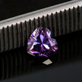 A loose lemon yellow moissanite gemstone cut into a heart shape, shown alongside other colour options.