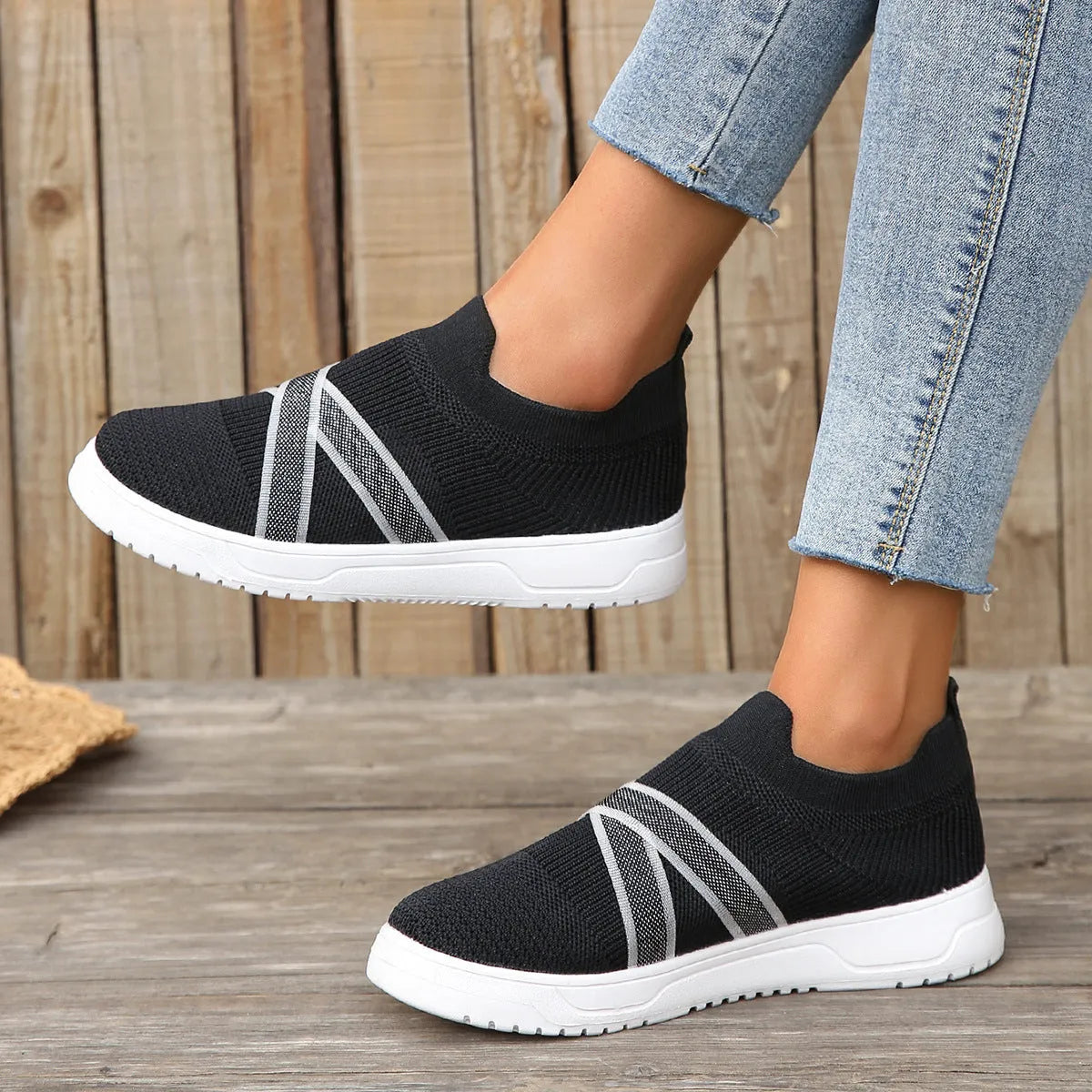 Women's black casual shoes with fabric mesh upper and flat rubber sole on neutral background