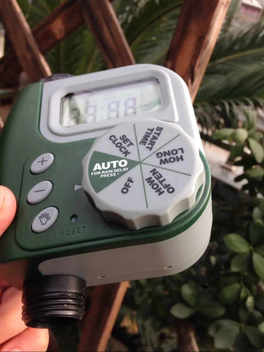 Green digital hose faucet timer with copper connector for automatic garden watering systems