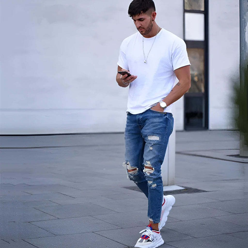 Men's distressed jeans in a deep blue wash on a size chart