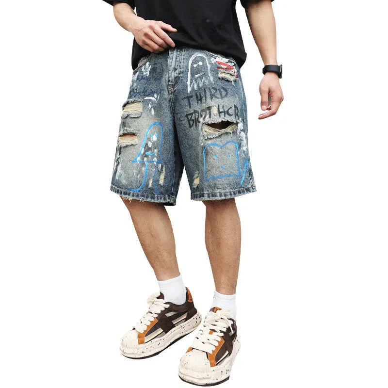 Blue men's denim shorts with ripped knees and graffiti-style print, featuring a straight leg and zipper fly.