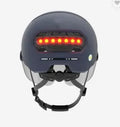 Adult cycling helmet with integrated red LED brake light on the rear, shown in two style options.