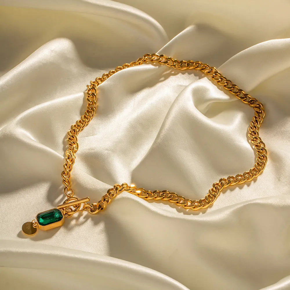 Gold tone geometric pendant necklace with emerald green zircon stone on Cuban link chain