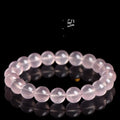 Close-up of a women's bracelet with polished round pink crystal beads on a single strand, showing smooth surface and sparkle.