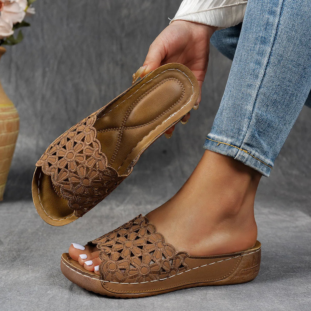Women's black wedge beach slippers with floral cutouts and an open fish mouth toe design.