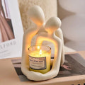 Modern heartwarming couple resin statue in milky white or gold colour on a wooden desk.
