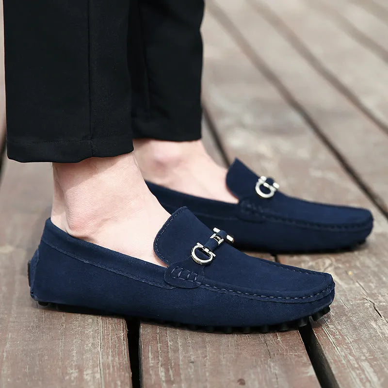 Men's black slip-on leather shoes with a square toe and matte finish on a plain background.