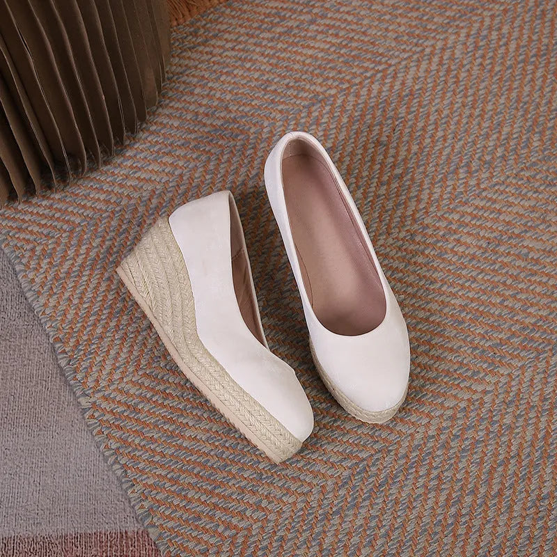 Apricot wedge high heel pumps with round toe and thick platform sole on a neutral background.