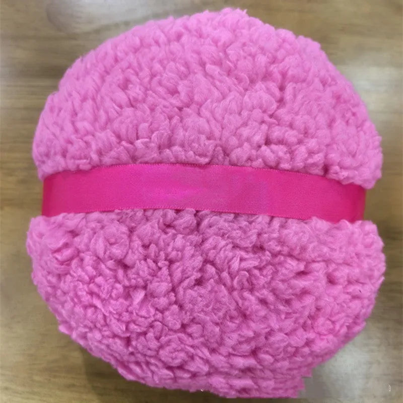 Oversized rectangular plush powder puff in skin colour on a pink background