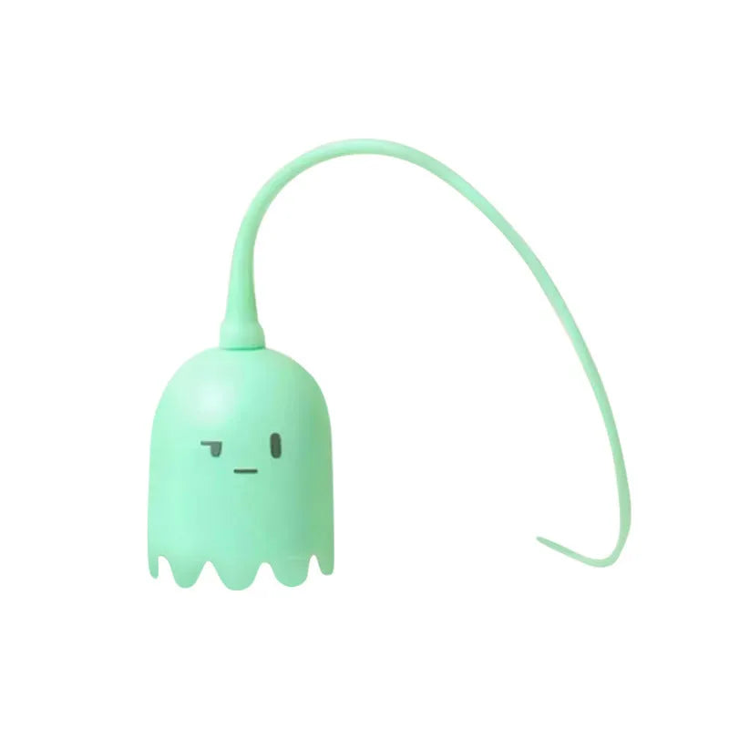 Green automatic cat toy with swinging silicone tails on a wooden floor.