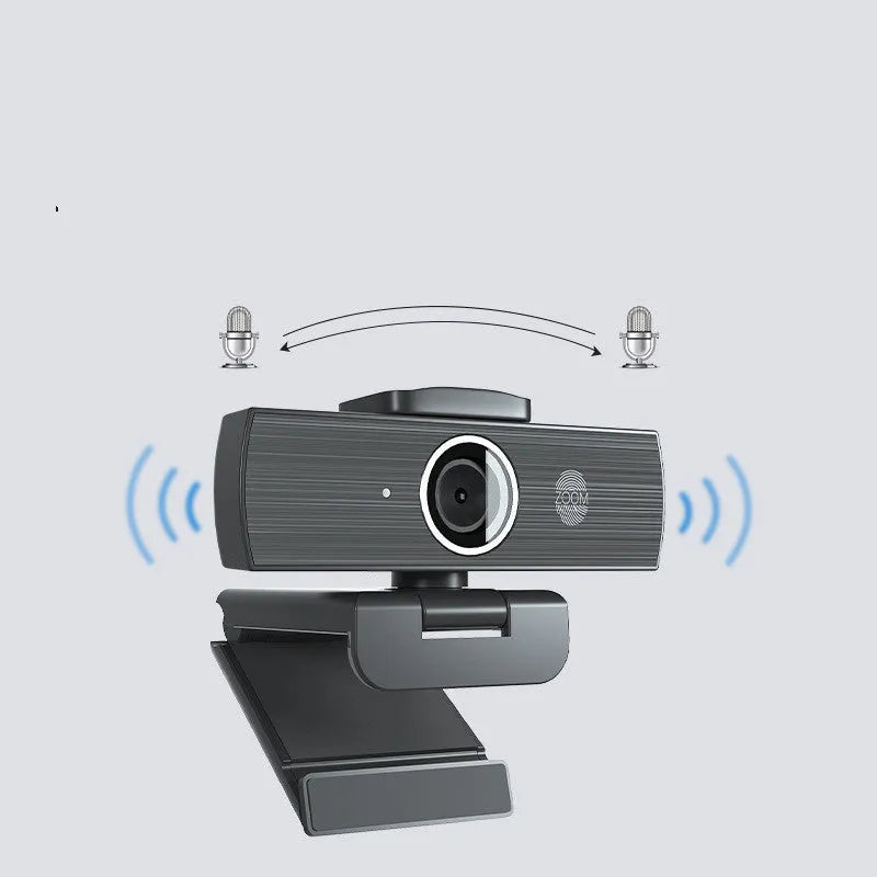 Black ABS USB web camera with magnetic privacy cover on a desk next to a laptop.