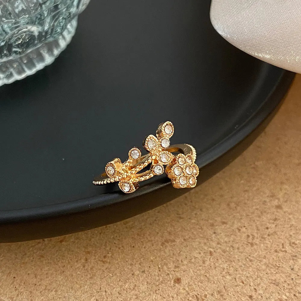 Copper open ring with flower and leaf design in gold colour.