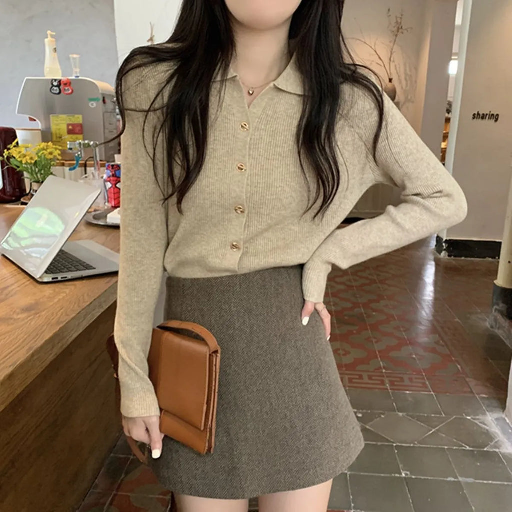 Beige long-sleeved viscose knitted cardigan hanging on a hanger, loose fit