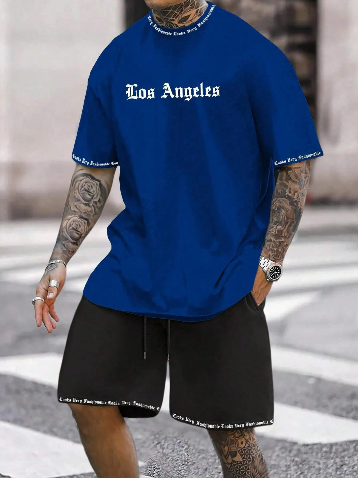 Mens blue sports style short sleeve top and shorts two-piece set on a plain background.