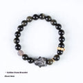 Close-up of a handmade lying rabbit obsidian bracelet in brass with grey agate beads.