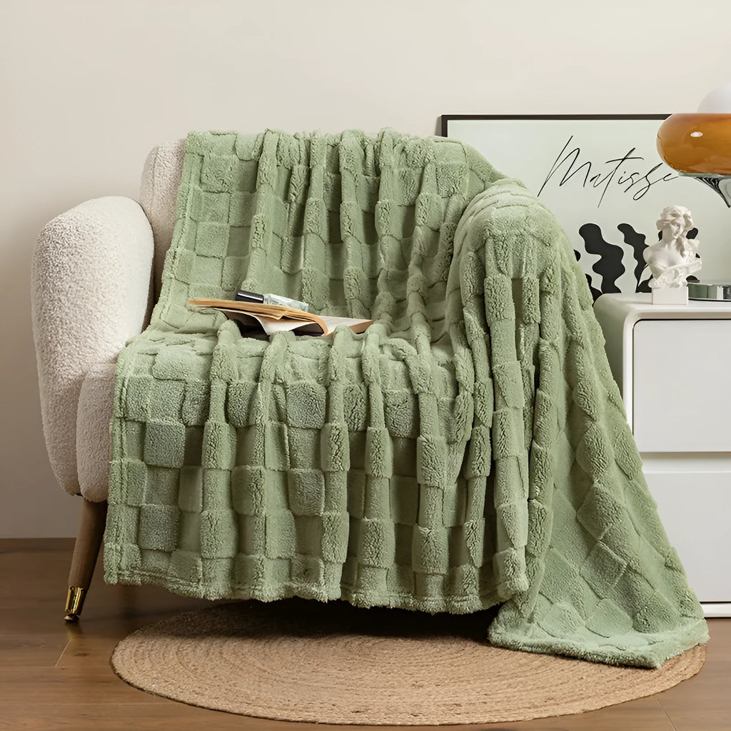Geometric pattern polyester blanket in milky white colour on grey sofa