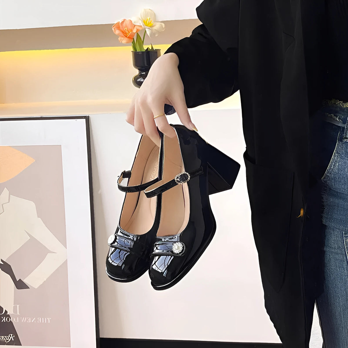 Women's black patent leather chunky heel shoes with round toe and buckle strap.