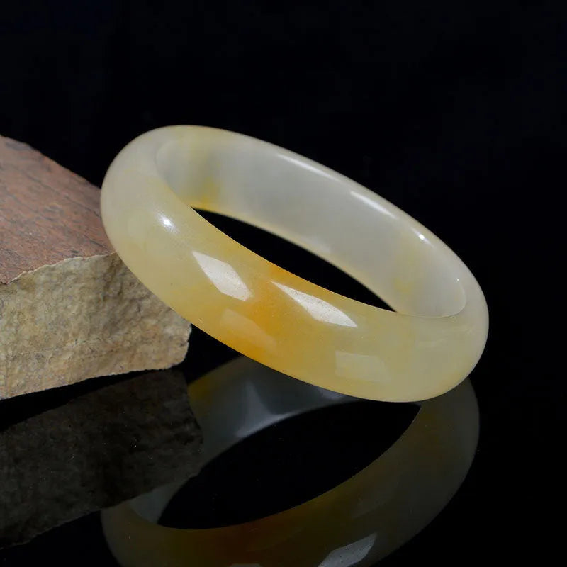 Polished light jade stone bracelet for women on a white background, showing Chinese style and smooth finish.