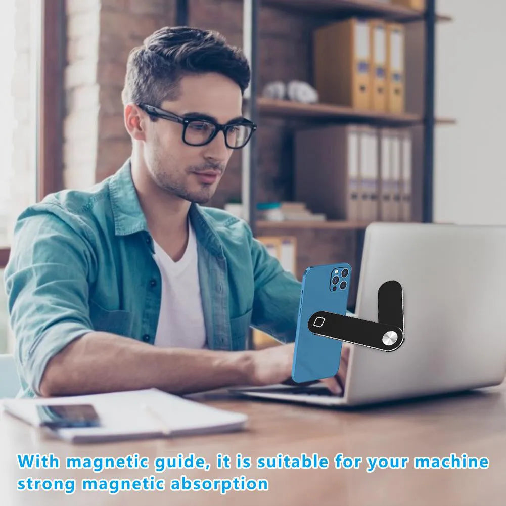 Black adjustable magnetic phone holder clipped to silver laptop showing phone mounted beside screen