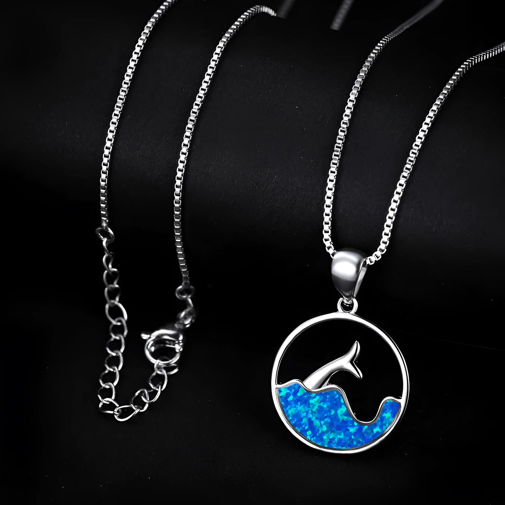 Close-up of a white gold electroplated geometric sea fishtail round pendant necklace on a model.