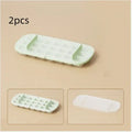 Yellow high-capacity ice cube tray with leverage handle and stored ice shovel.