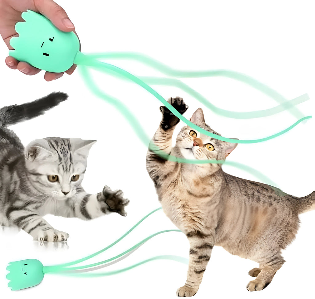 Green automatic cat toy with swinging silicone tails on a wooden floor.