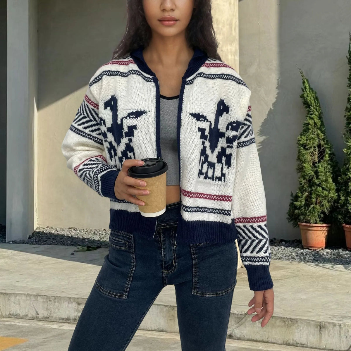 White women's cardigan with jacquard stripe pattern, zip front, and lapel collar on a hanger.