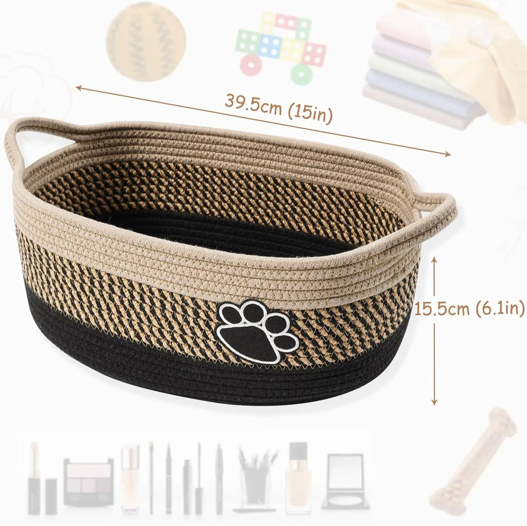 Small light beige handwoven cotton rope storage basket with wooden handle on a wooden table.