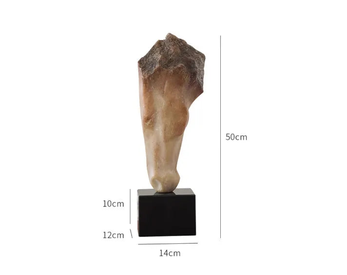 Tall abstract horse head sculpture with carved texture on a desk surface.