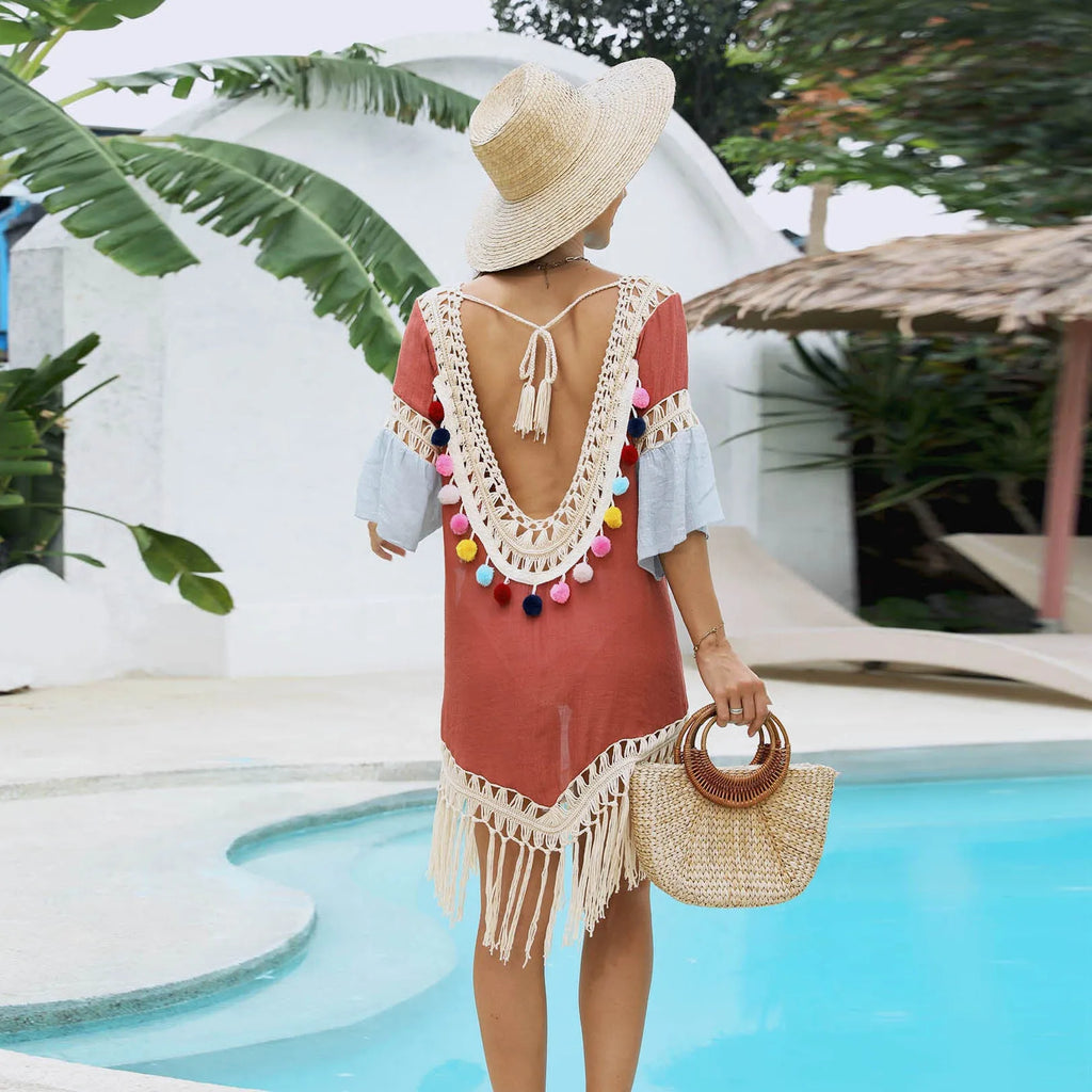Orange floral print beach overskirt with hand crochet detail and tassels, laid flat.